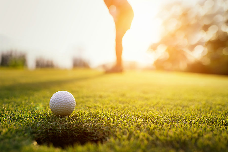 Specialized Business Insurance - View of a Golf Ball Going into Hole on a Golf Course at Sunset